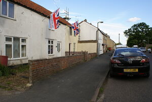 Harry's House in 2012. is painted white, at the far side of the flags and lampost